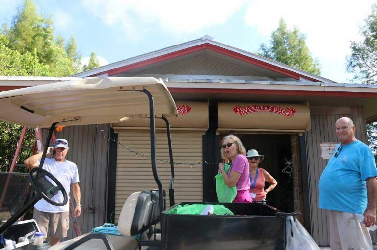 A group of people are standing in front of a golf cart.