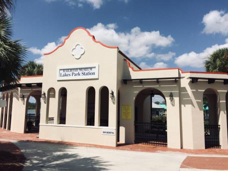 A white building with arches and a sign that says lake park station