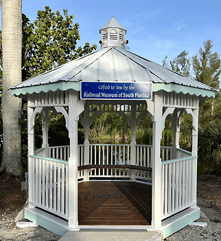 White gazebo with a blue sign stating