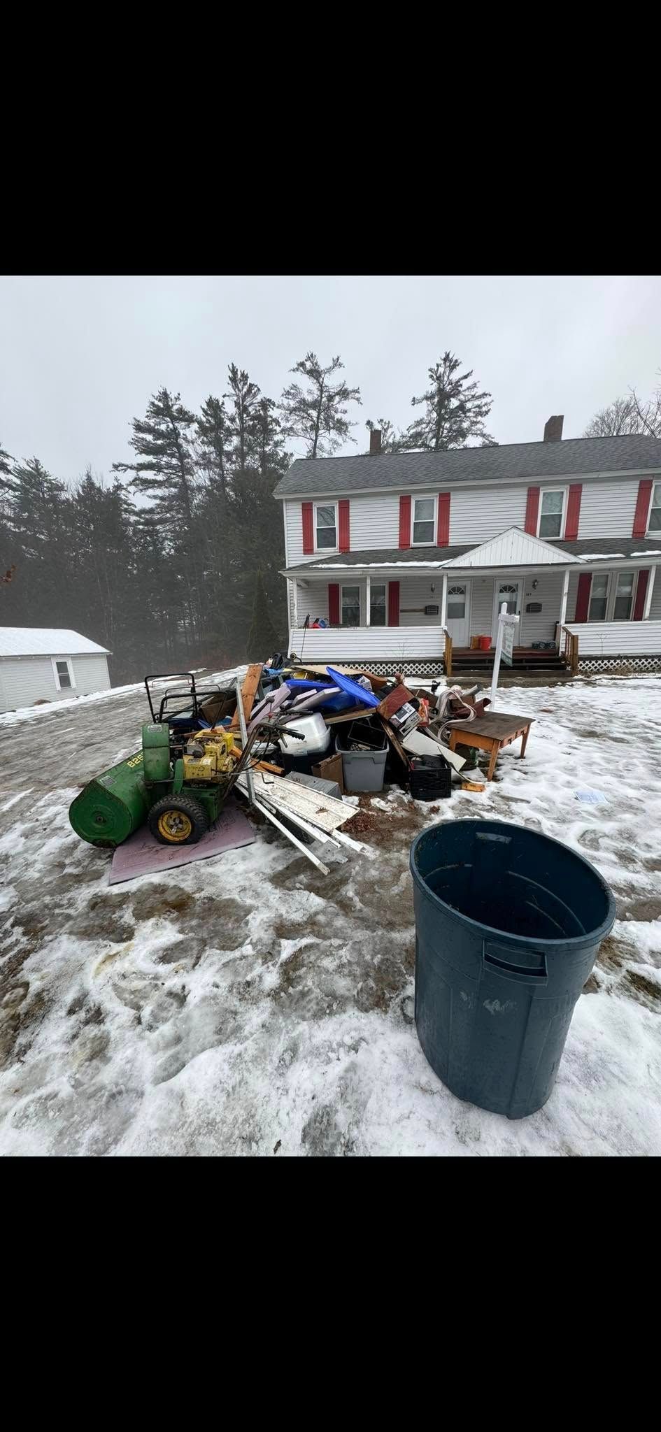Woman in straw hat smiles, holding wine glass near a lake.