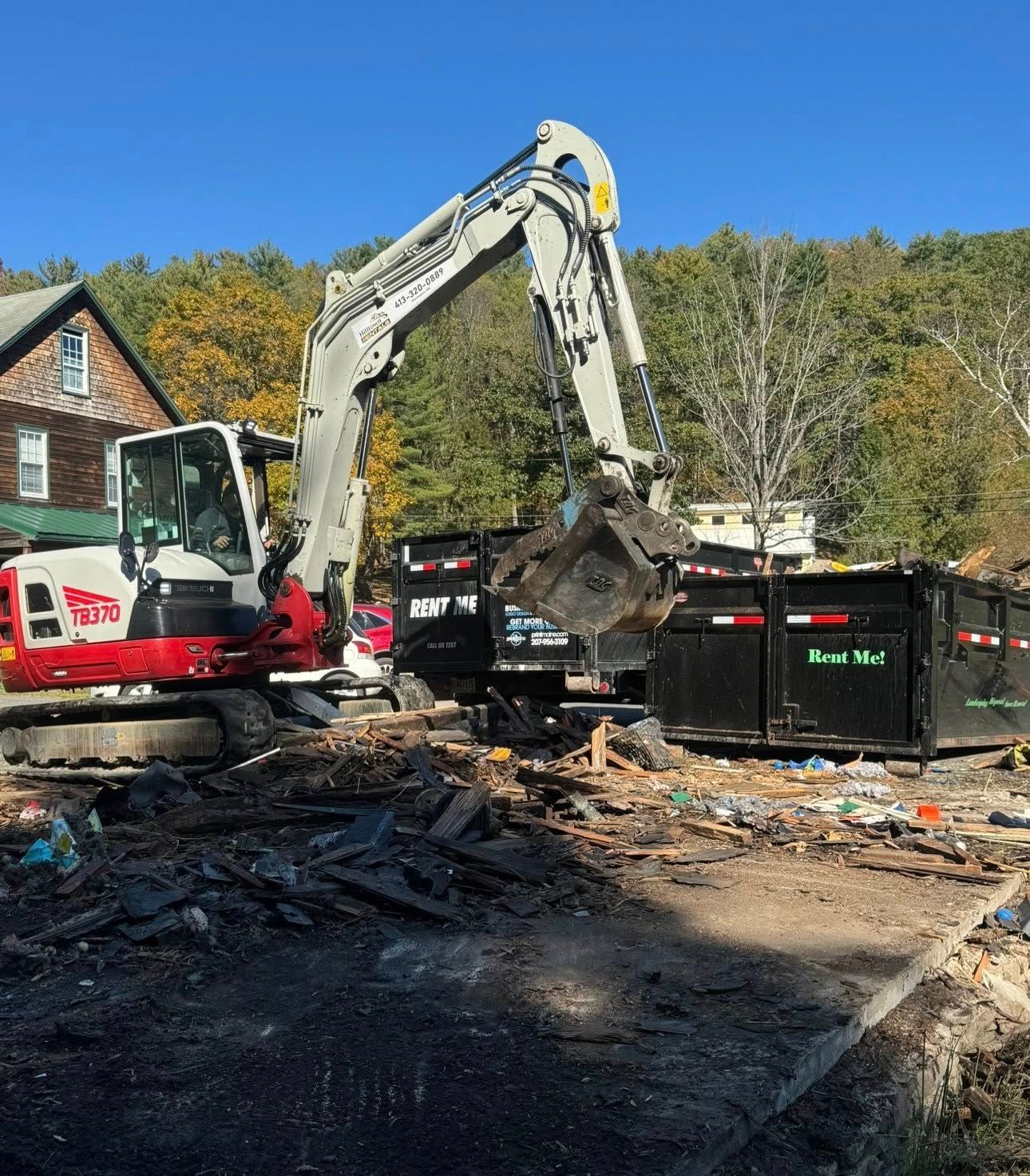 Woman in straw hat smiles, holding wine glass near a lake.