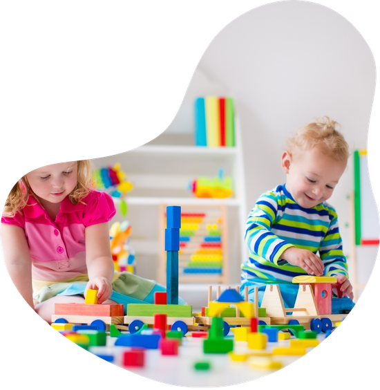 A boy and a girl are playing with wooden blocks on the floor.