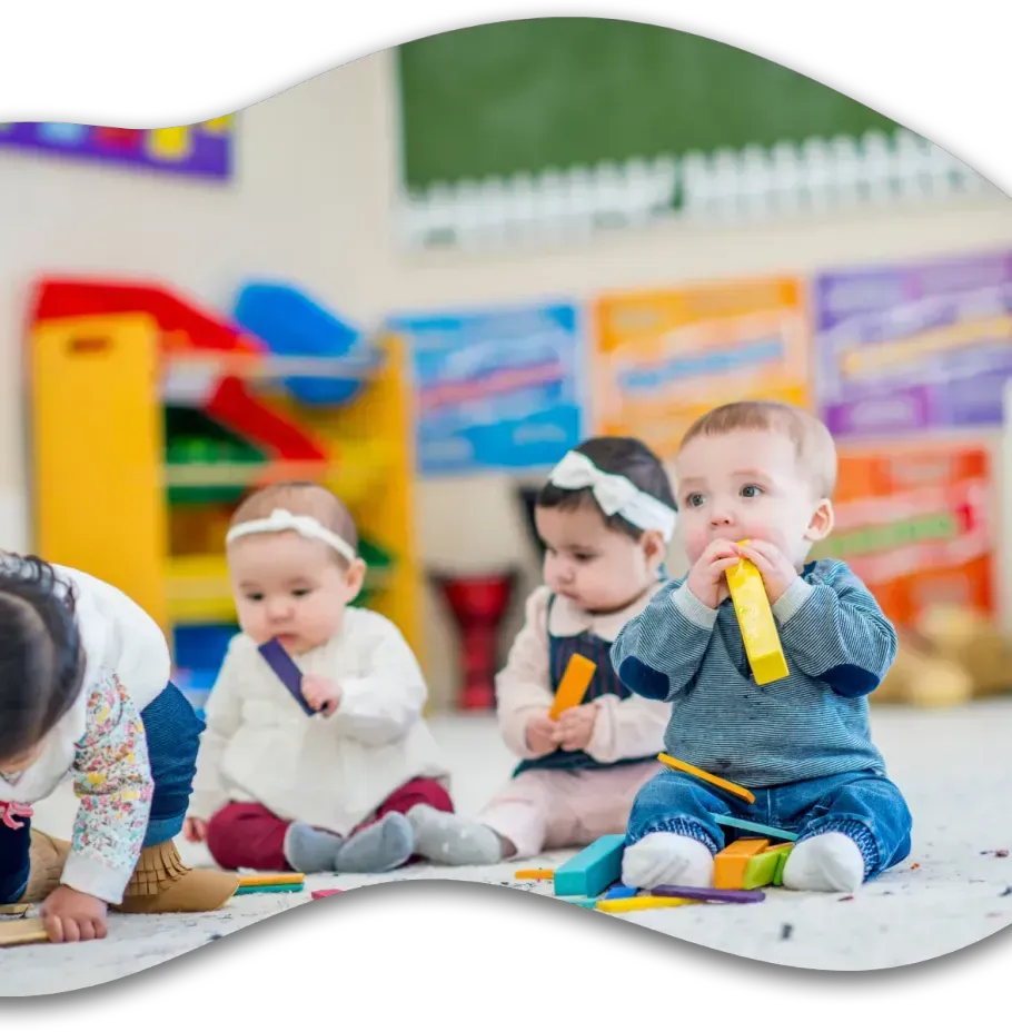 A group of babies are sitting on the floor playing with toys.