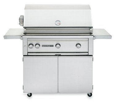 A stainless steel grill is sitting on top of a cart.