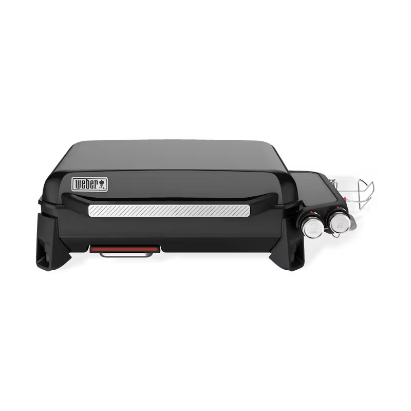 A black weber grill is sitting on a white surface.