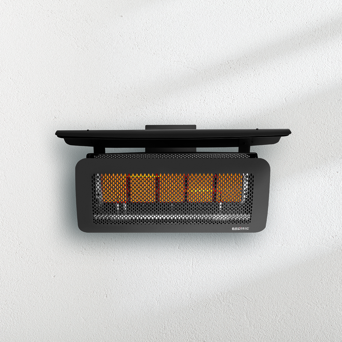 A black heater is hanging on a white wall.