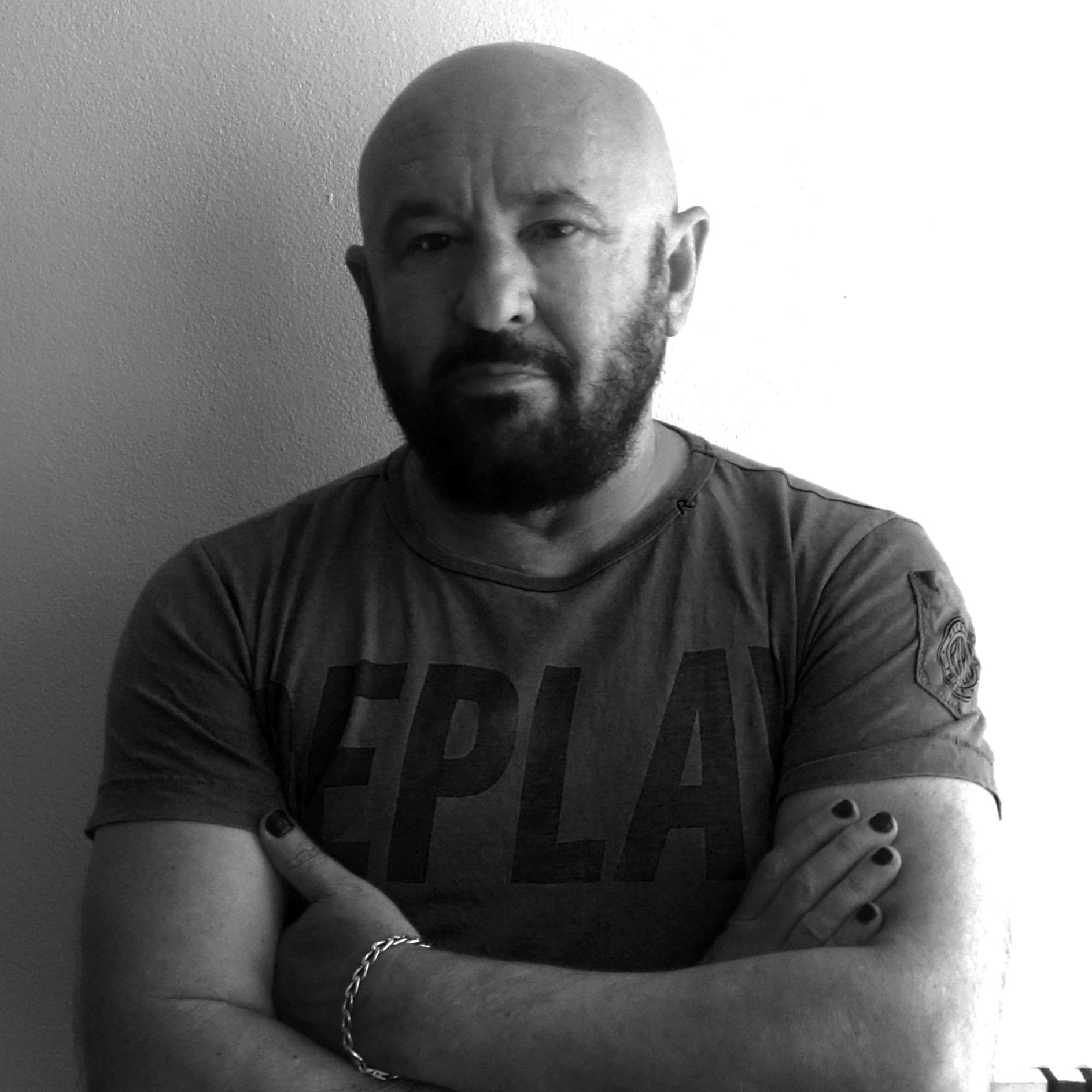 A bald man with a beard is wearing a t-shirt that says epla