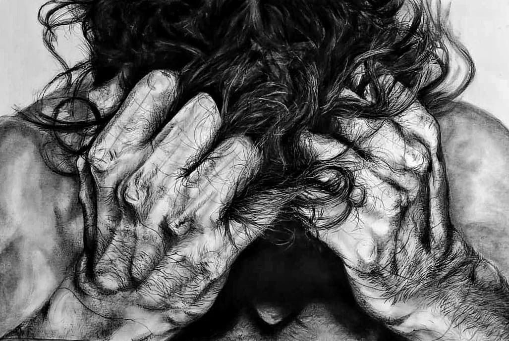 Person with hands covering face; dark hair and shadowed body suggest distress.