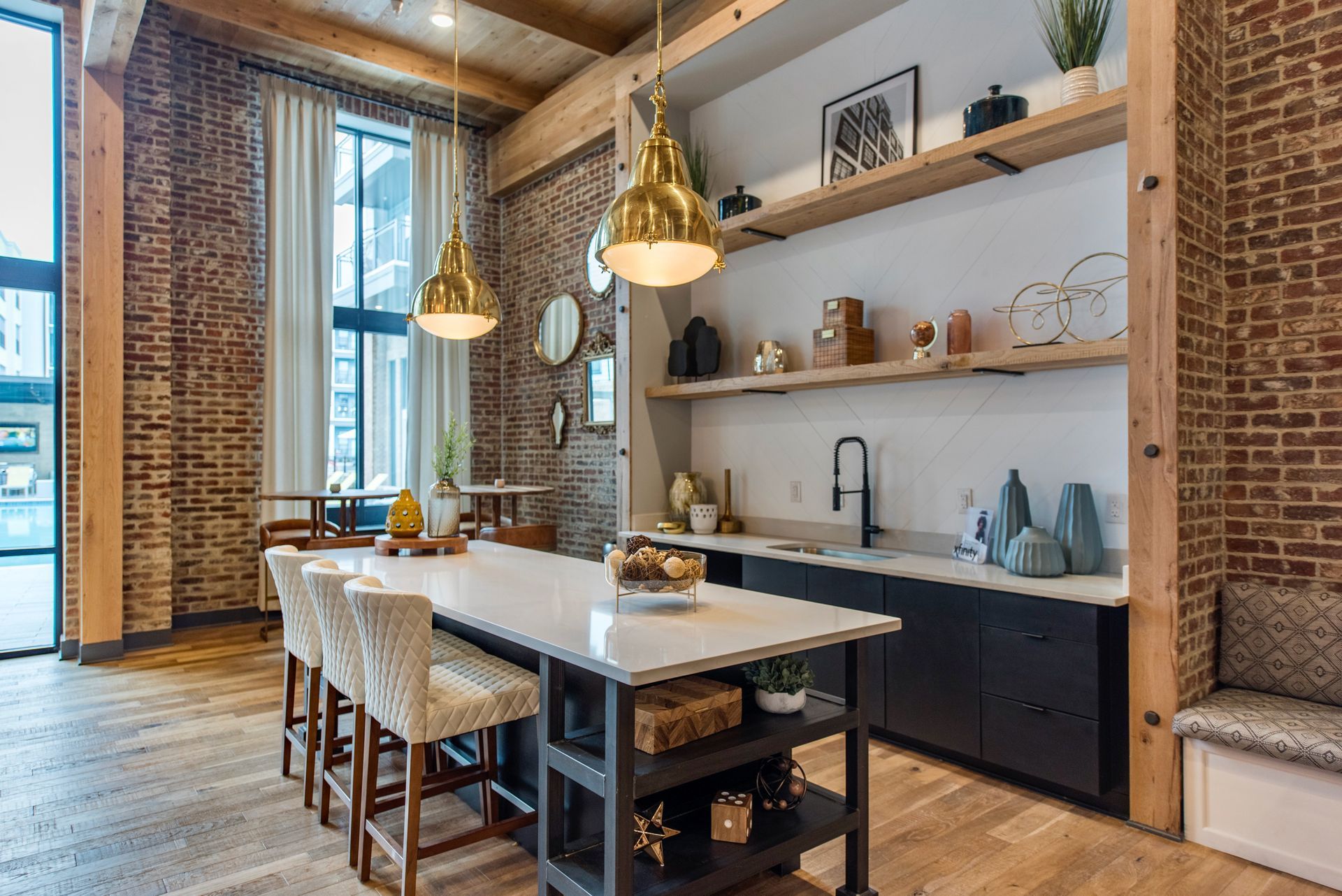 Apartment kitchen with a large island and a brick wall.