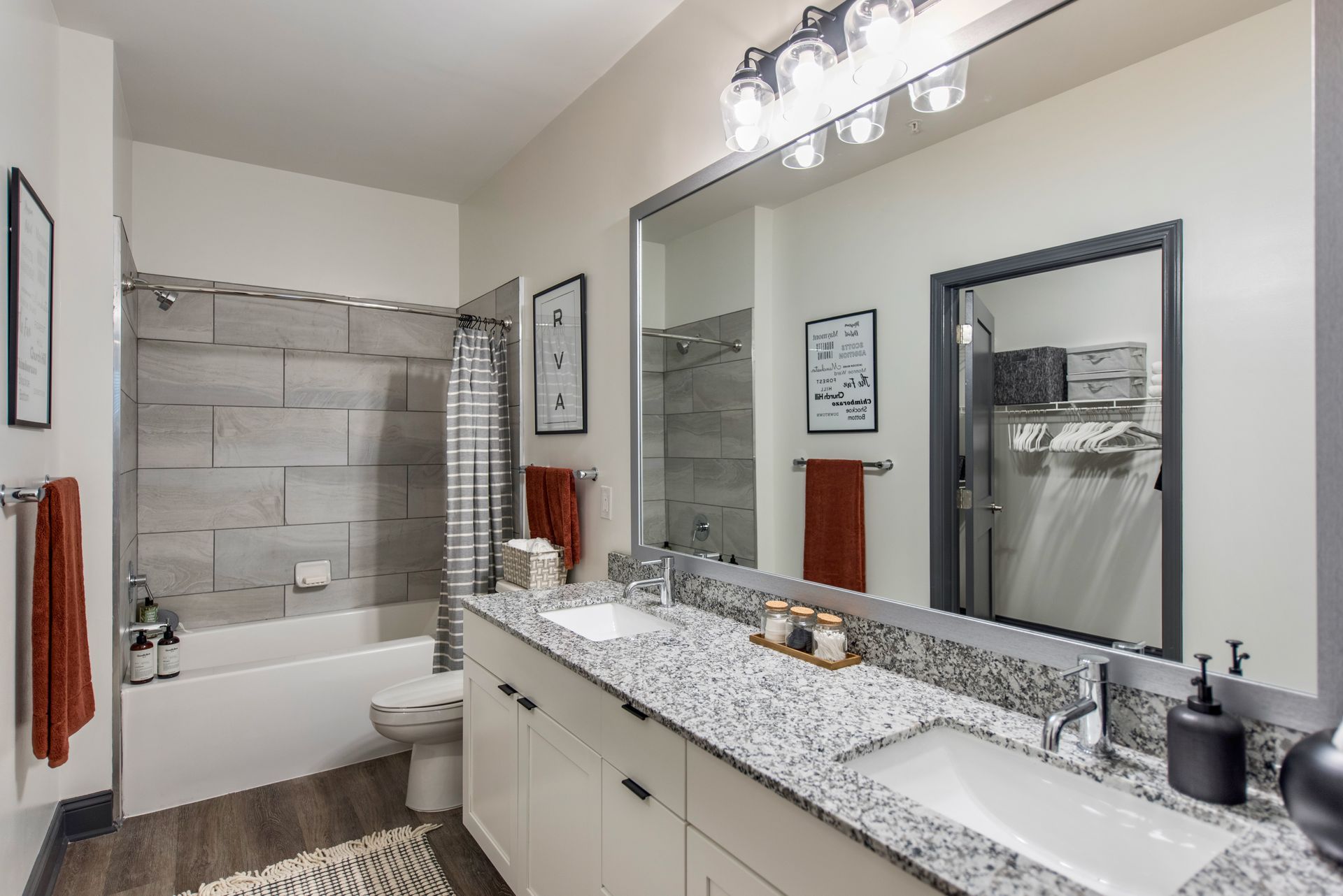A bathroom with two sinks, a tub, and a large mirror.