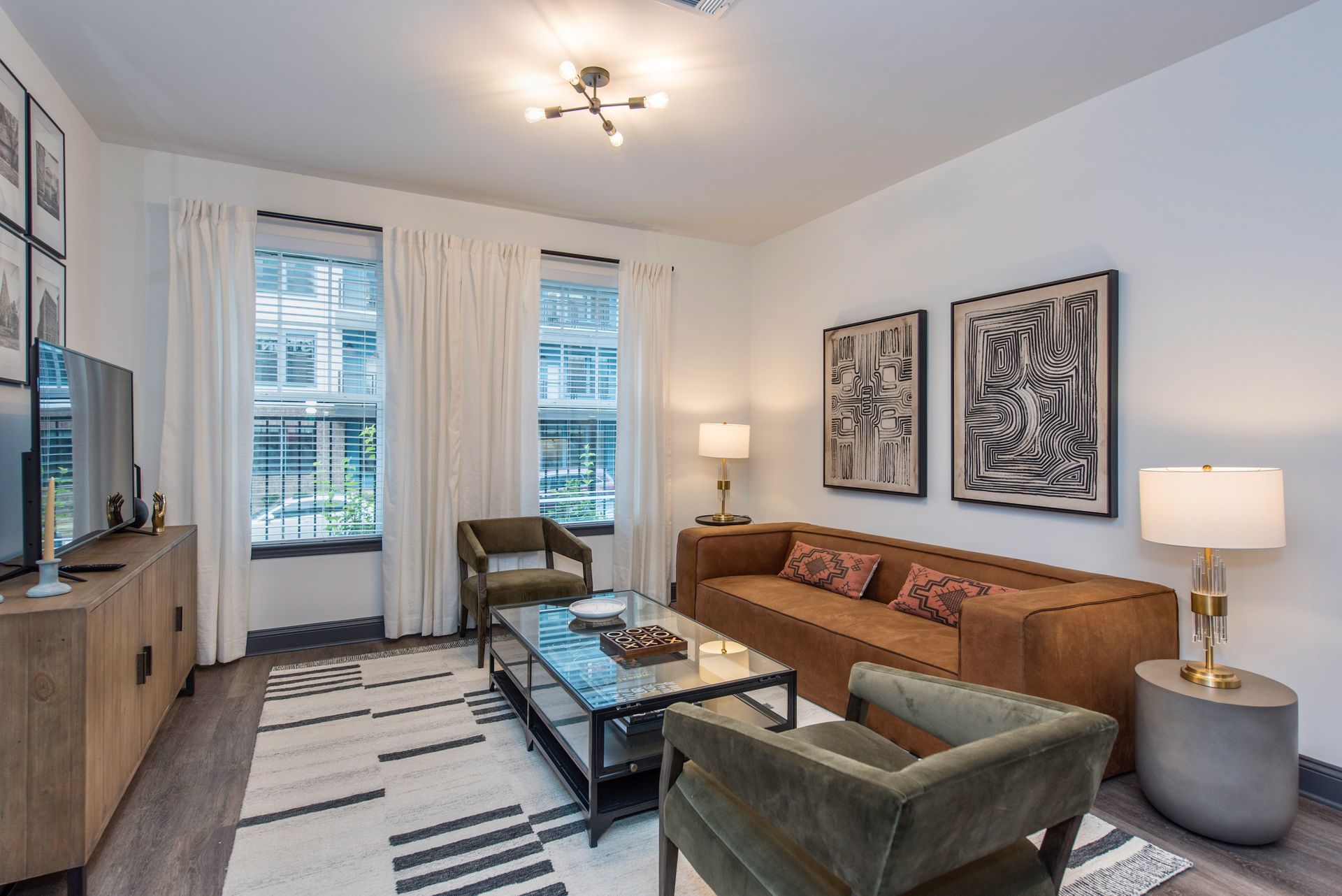 A living room with a couch, chairs, coffee table, and television.