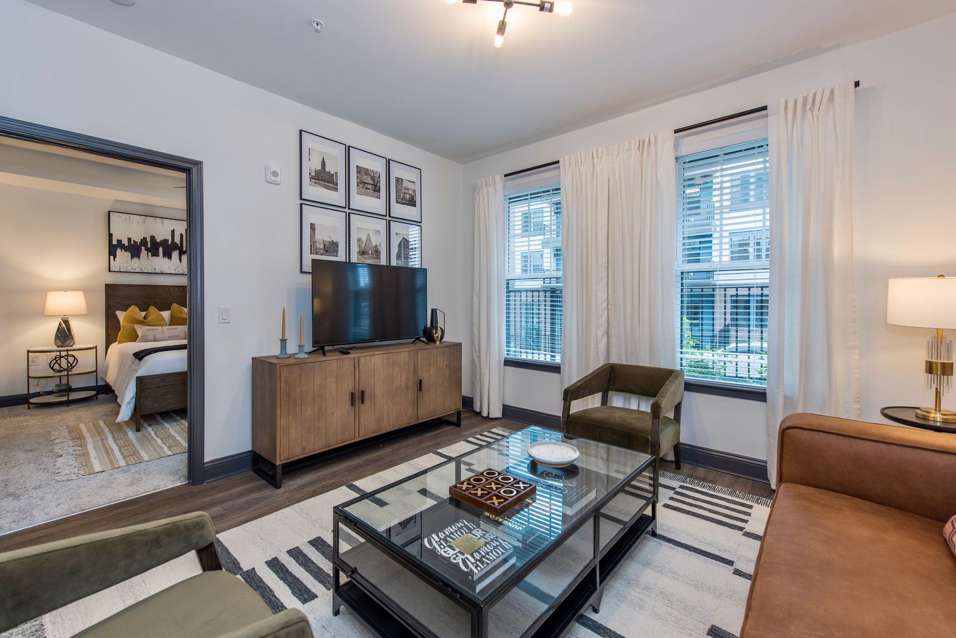 A living room with a couch , chairs , coffee table and television.