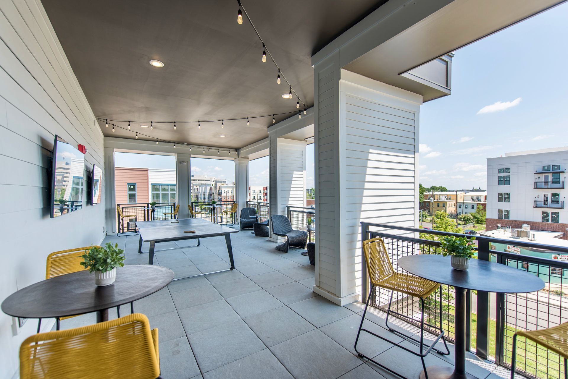 There are tables and chairs on the outdoor balcony.