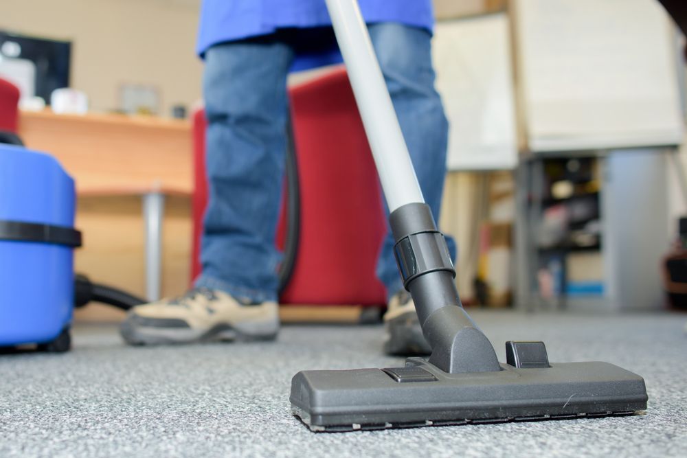 Person Vacuuming a Carpeted Office Floor — Kingaroy Carpet Cleaners in Wondai, QLD