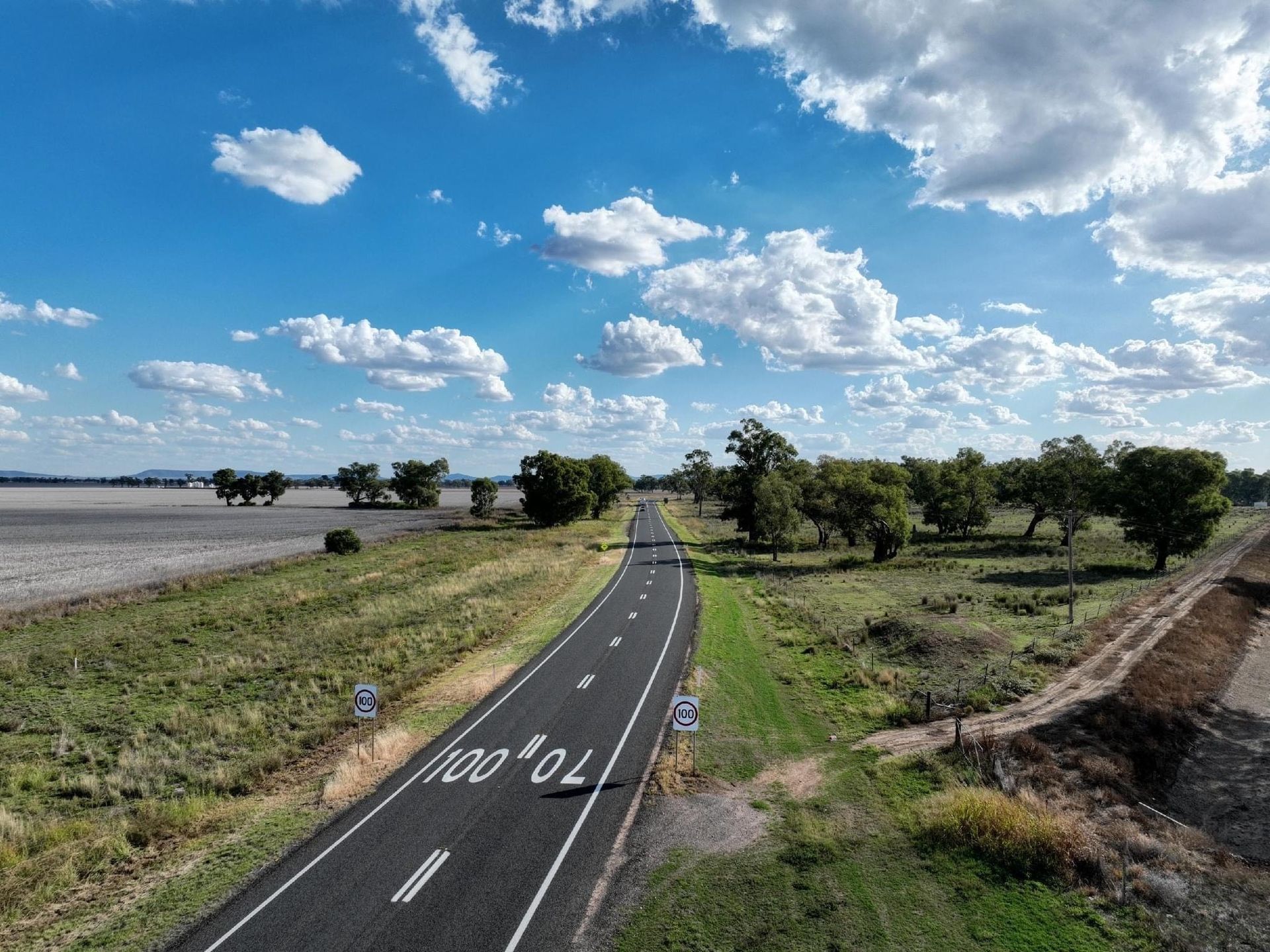 An aerial view of a road going through a field.