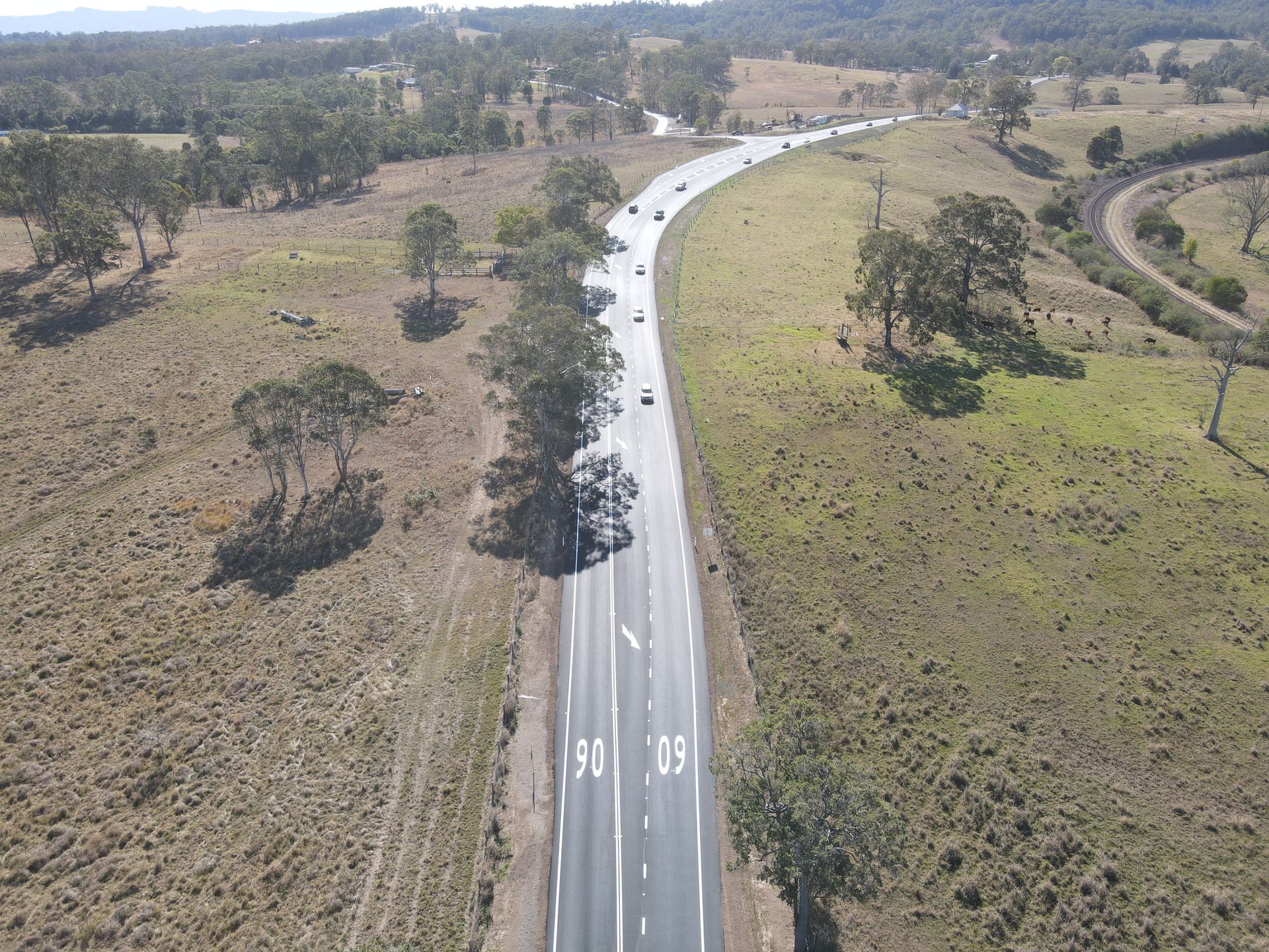 An aerial view of a highway going through a field