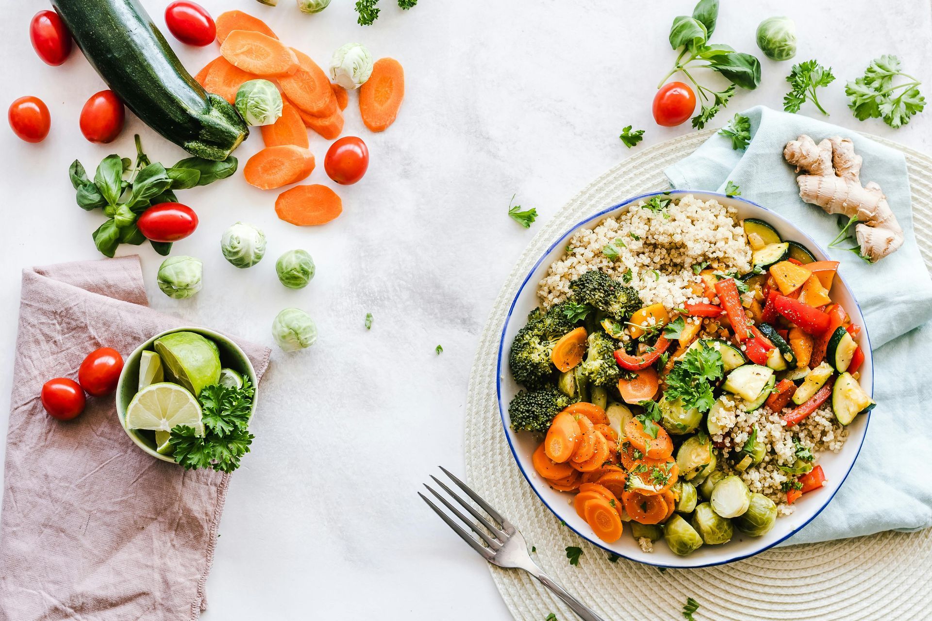 A plate of vegetables and rice on a table with a fork.