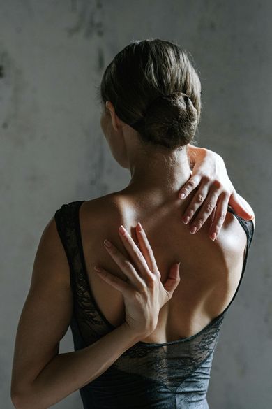 A woman is holding her hands on her back.