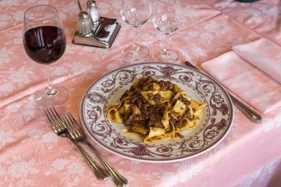 Piatto di ravioli conditi con salsa di pomodoro rosso su un piatto decorato.