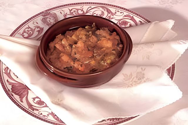 Tavolo da pranzo moderno di colore nero con piatti, tovaglioli e bicchieri da vino per ogni posto a sedere.