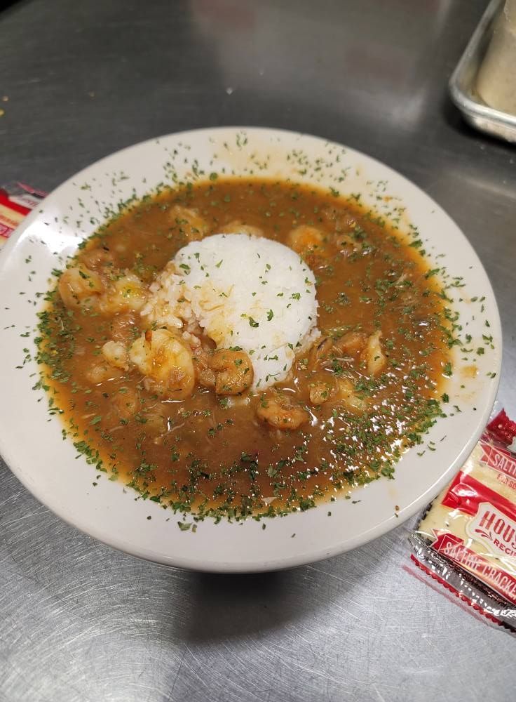 Bowl of shrimp Creole with rice, sprinkled parsley.