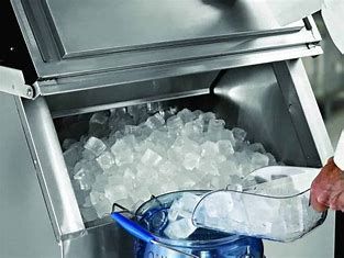 A person is pouring ice into a bucket from a machine.