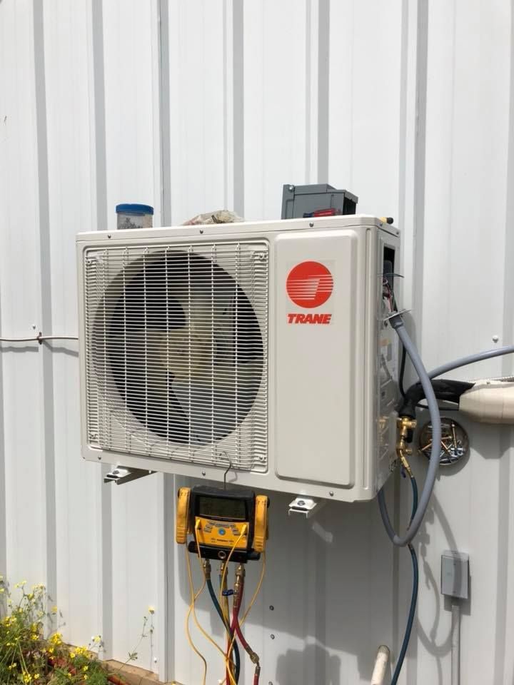 A trane air conditioner is mounted on the side of a building.