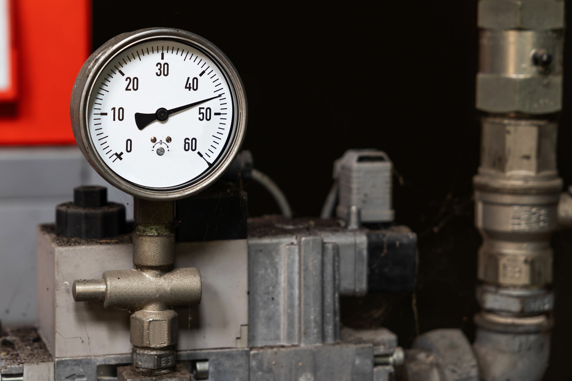 Pressure gauge showing 15, attached to pipes and machinery.