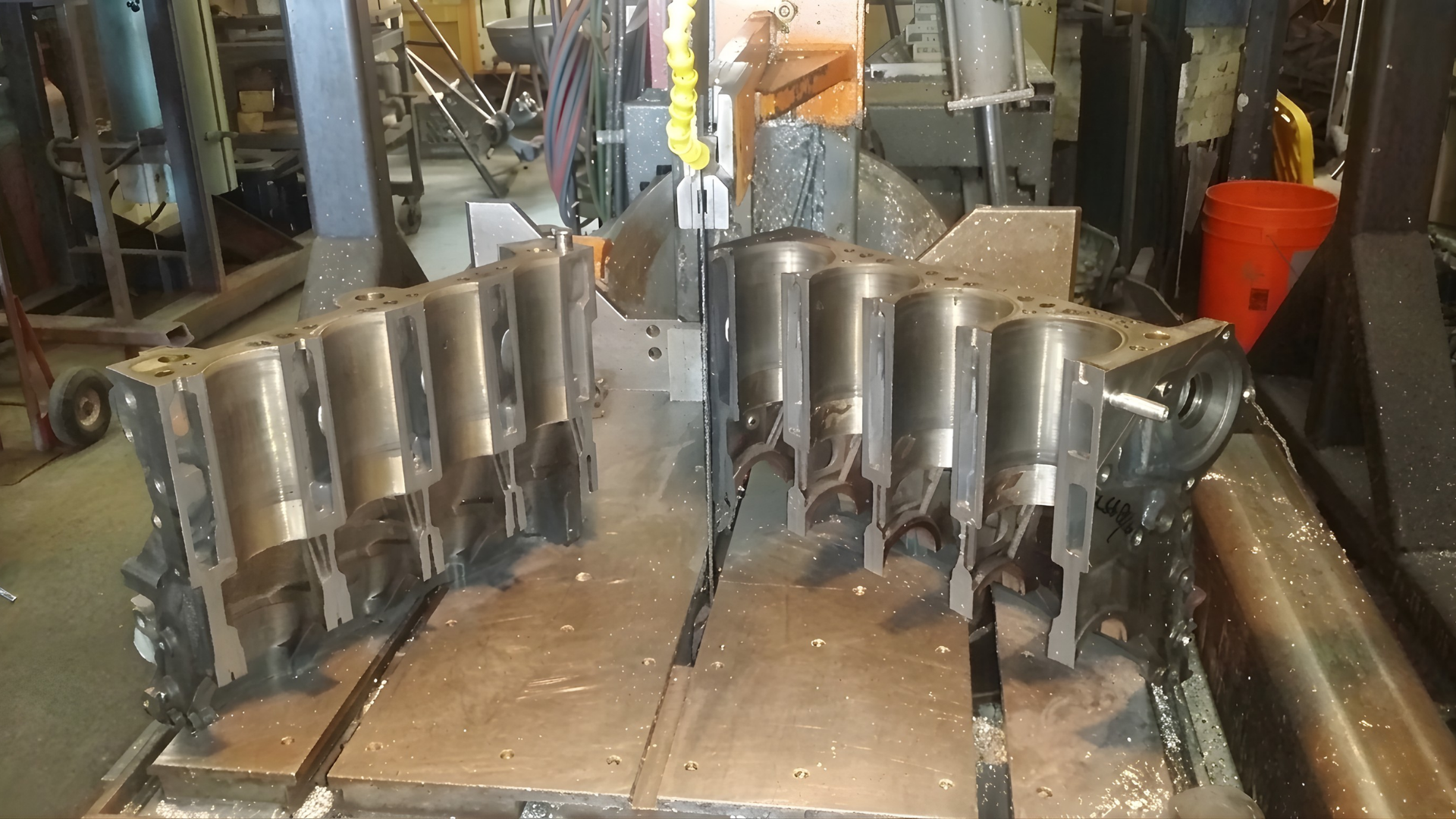 Metal cylinders lined up on a workshop bench with tools and equipment in the background