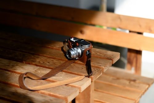 camera on a wooden table with wooden bench