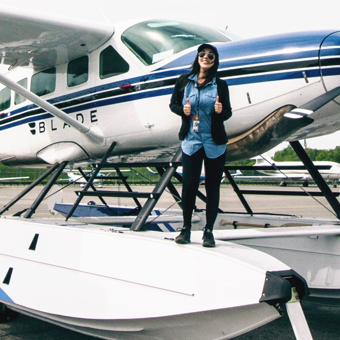 A woman stands in front of a plane with the number 1 on it