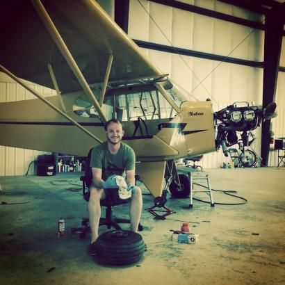 A man is sitting in front of a plane that says parsons