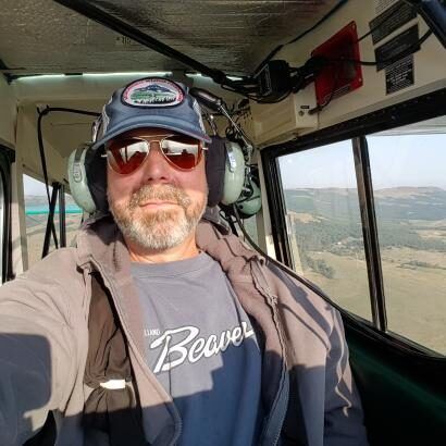 A man is taking a selfie in the cockpit of a helicopter.