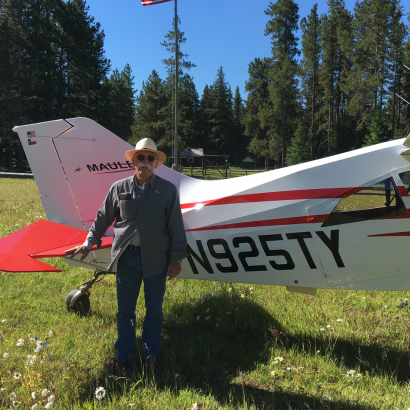 A man stands in front of a plane with n925ty written on it