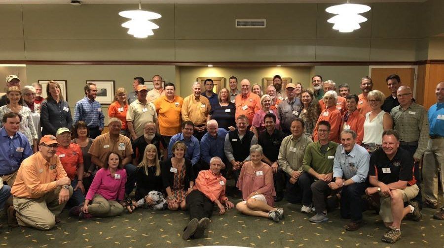 A large group of people are posing for a picture in a room.