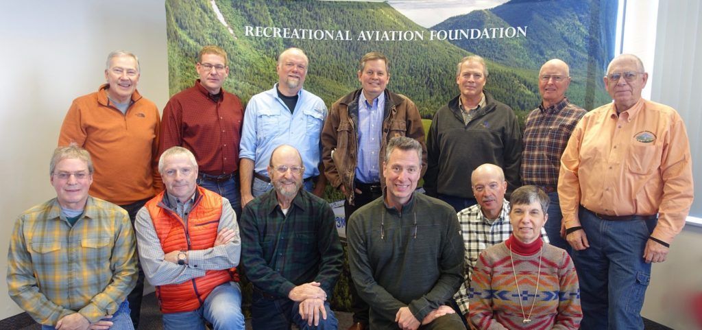 A group of people posing for a picture in front of a sign that says national aviation foundation
