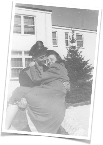 A black and white photo of a man carrying a woman in his arms