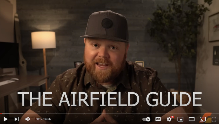 A man in a hat is talking about the airfield guide