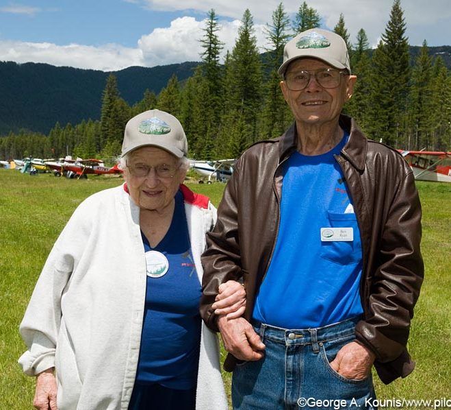 A man and a woman are posing for a picture in a field