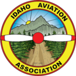The logo for the idaho aviation association has a propeller and mountains in the background.
