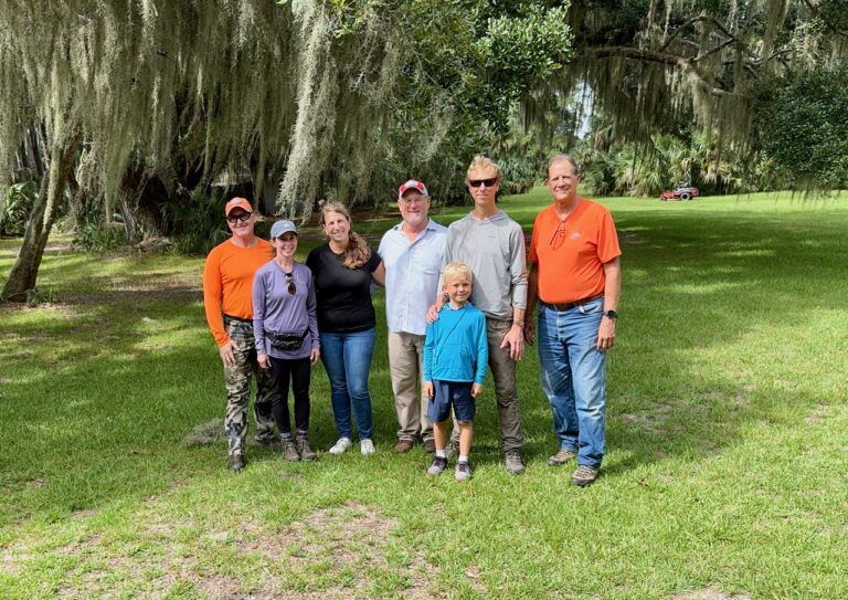 A group of people are posing for a picture in a park.