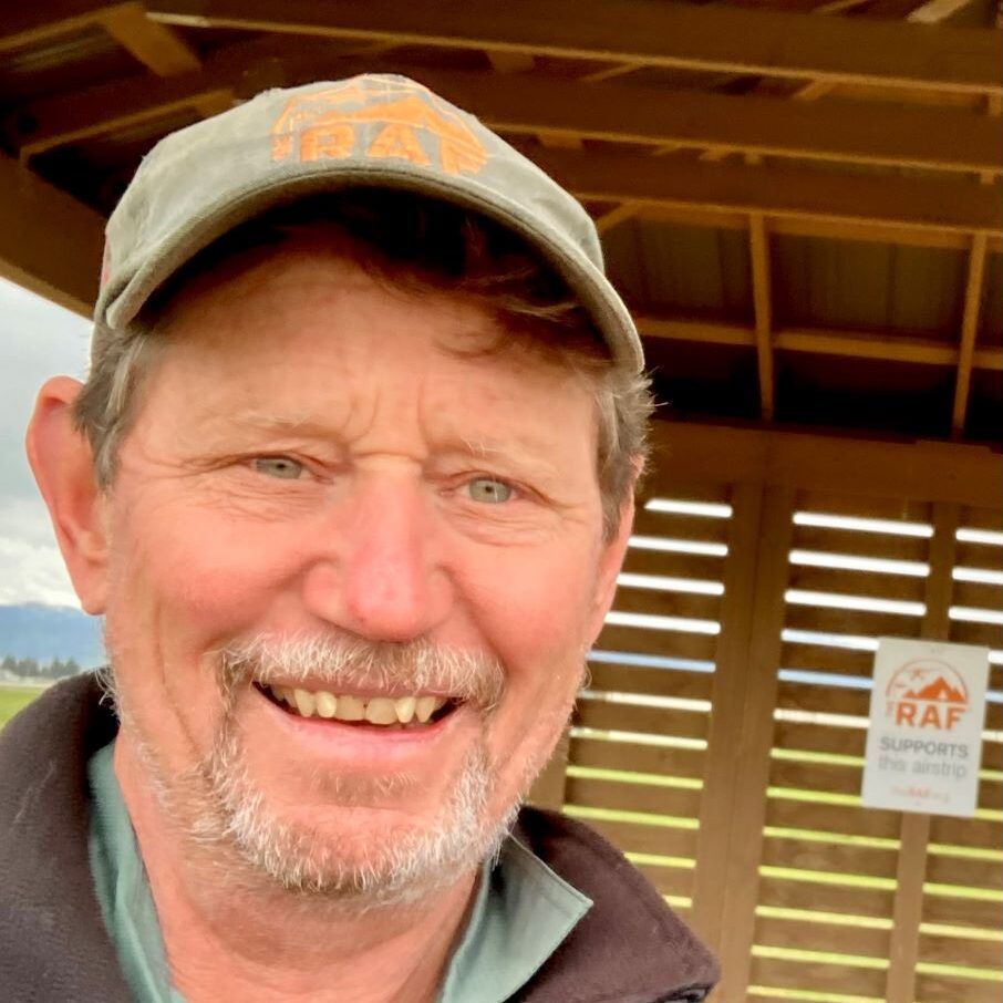 Smiling man in a cap, standing in a gazebo; RAF logo on the wall behind.