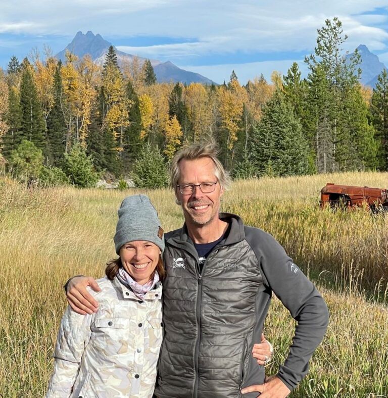 A man and a woman are posing for a picture in a field.