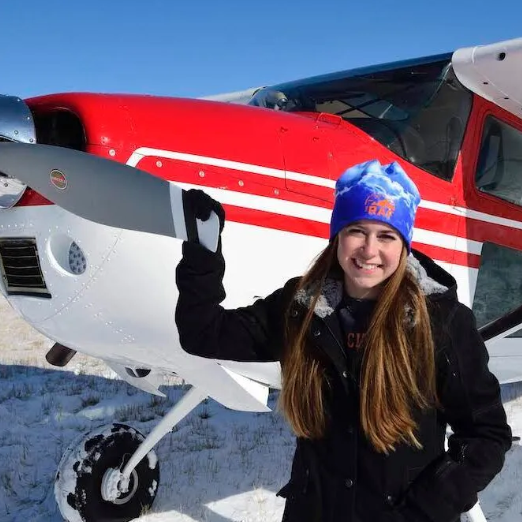 A man stands in front of a sign that says toncass national forest