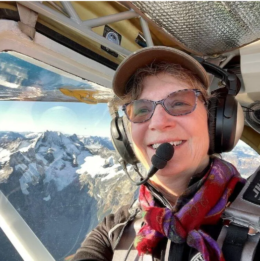 A man stands in front of a sign that says toncass national forest