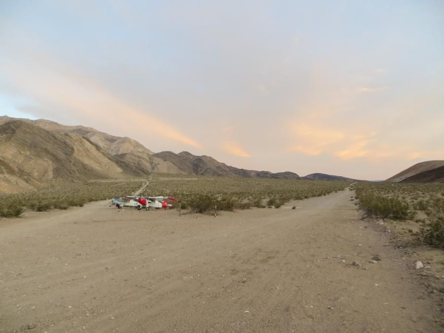A dirt road in the desert with mountains in the background