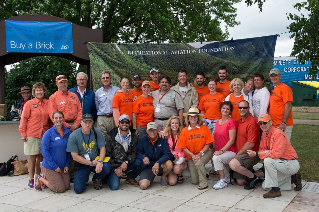 A group of people posing in front of a sign that says buy a hook