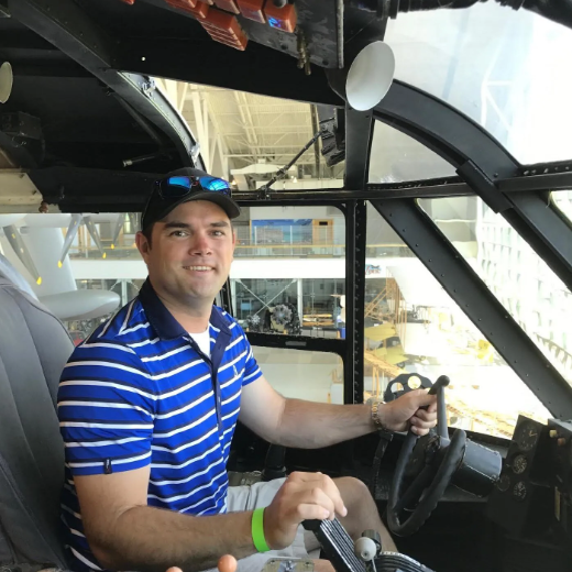 A man stands in front of a sign that says toncass national forest