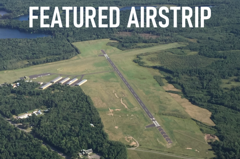 An aerial view of a featured airstrip surrounded by trees