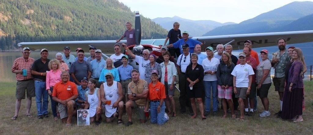 A group of people posing for a picture in front of a plane